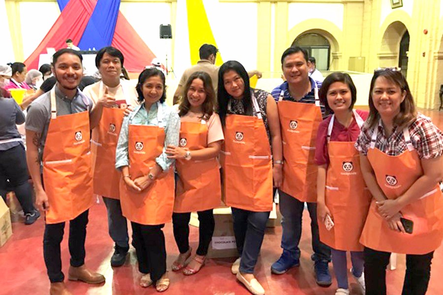 Volunteers posing and pausing for a break during the Rise Against Hunger Meal Packaging Activity at the Department of Health Manila Convention Hall